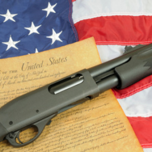 Gun Control -- Rifle lying over Constitution and flag